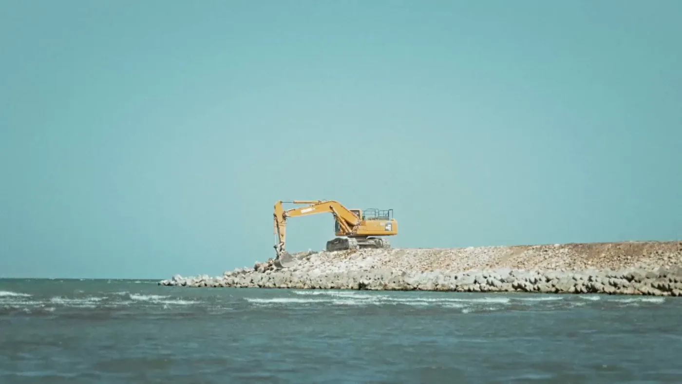 Экскаватор отсыпает каменный мол Sea Breeze, 2023 год (какой именно мол — в ролике не сказано)