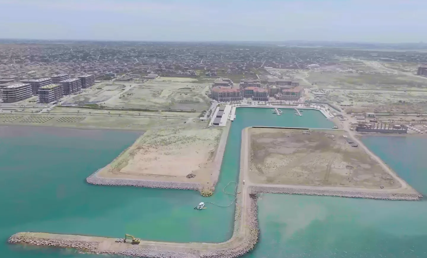 Участок BRABUS ISLAND Baku — намытый полуостров у гавани Marina, май 2026 года. Позади — Marina Village